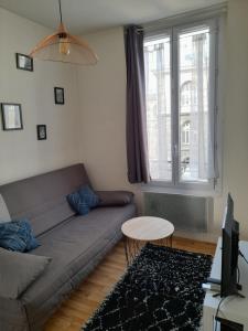 a living room with a couch and a table at Cosy 2 pièces typiquement parisien à Notre-Dame in Paris