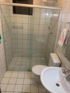 a bathroom with a shower and a toilet and a sink at Apto frente à praia - Guilhermina in Praia Grande