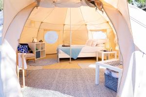 a room with a tent with a bed and a table at Busselton Villas and Glamping Village in Busselton