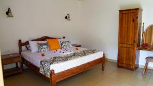 a bedroom with a bed and a wooden cabinet at Villa Antonia in La Digue