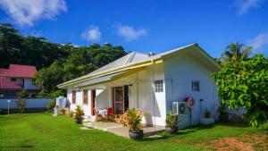 a small white house with a yard at Villa Antonia in La Digue