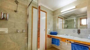 
a bathroom with a shower, sink, and mirror at Tooleybuc Club Motor Inn in Tooleybuc
