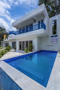 a villa with a swimming pool in front of a house at SaffronStays Kairos Athena, Karjat - Greek style pool villa near Camp Max in Karjat