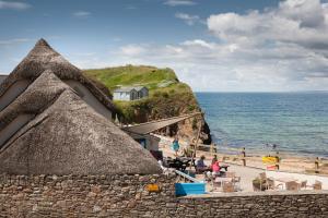 a view of a beach with a building and the ocean at Hope & Anchor in Hope Cove