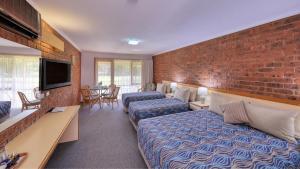 a hotel room with two beds and a brick wall at Tooleybuc Club Motor Inn in Tooleybuc