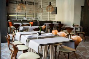 a restaurant with tables and chairs in a room at Holiday Inn Vilnius Center by IHG in Vilnius