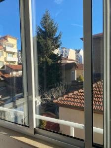 a window with a view of a roof at PLEVEN Rooms in Pleven