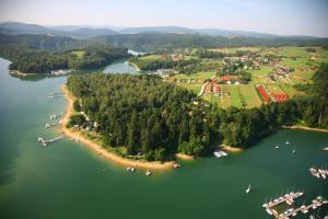 an island in the middle of a lake with boats at Szeptucha in Polańczyk