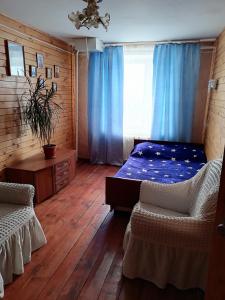 ジヴェエヴォにあるPo Svyatym Mestamのベッドルーム1室(ベッド1台、青いカーテン付きの窓付)