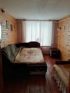 ジヴェエヴォにあるPo Svyatym Mestamのソファ付きの客室の大型ベッド1台