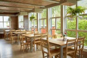 a restaurant with wooden tables and chairs and windows at Skjåk Turistheim in Skjåk +22 photos
