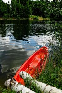 a red kayak in the water next to some trees at Haus Seeblick in Dippoldiswalde