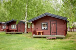 a row of wooden cottages in the grass at Skjåk Turistheim in Skjåk