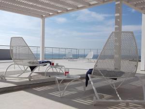 two chairs and a table on a patio with the ocean at Brezza Di Grecale in Trapani