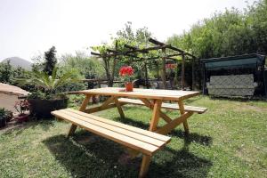 einem Picknicktisch aus Holz und einer Bank im Hof in der Unterkunft Casaventre in Vietri