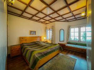 - une chambre avec un grand lit et une fenêtre dans l'établissement Birdwood Cottages, à Dalhousie