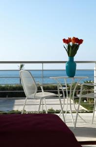 una mesa con dos sillas y un jarrón con flores en Brezza Di Grecale, en Trapani