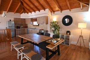 a kitchen and dining room with a wooden table and chairs at Vista Mare in Nea Irakleia