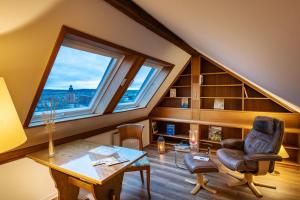 an attic room with a large window and a chair at Hotel Bürgerhof Wetzlar in Wetzlar