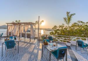 a table and chairs on a patio with a view of the water at Moustache Udaipur Luxuria in Udaipur