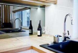 due bottiglie di vino sedute su un bancone della cucina di Apartament HORYZONT "ZŁOTA" a Polanica-Zdrój