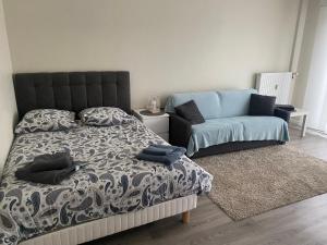 ein Schlafzimmer mit einem Bett und einem Sofa in der Unterkunft Appartement Parc de Fresnoy in Roye