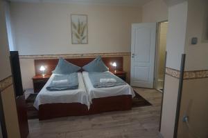 Postel nebo postele na pokoji v ubytování Hotel Ajka Üzletház Panzió Ajka