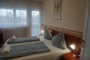 Un pat sau paturi într-o cameră la Hotel Ajka