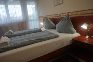 Postel nebo postele na pokoji v ubytování Hotel Ajka Üzletház Panzió Ajka