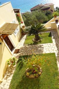 A garden outside Natalia Apartment B with panoramic sea views of Agios Gordios bay