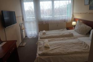 Postel nebo postele na pokoji v ubytování Hotel Ajka Üzletház Panzió Ajka