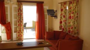 salon z kanapą, stołem i oknem w obiekcie Natalia Apartment B with panoramic sea views of Agios Gordios bay w mieście Agios Gordios
