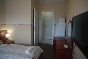 Postel nebo postele na pokoji v ubytování Hotel Ajka Üzletház Panzió Ajka