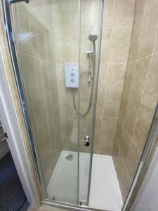 a shower with a glass door in a bathroom at The Walnut Suite lovely one bedroom flat in Stoke. in Plymouth