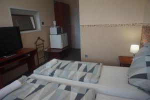 Postel nebo postele na pokoji v ubytování Hotel Ajka Üzletház Panzió Ajka