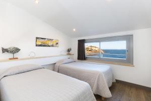 2 Betten in einem Zimmer mit Fenster in der Unterkunft Hotel La Vigie - Face à la mer in Cerbère