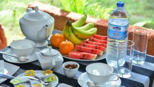 una mesa con una bandeja de fruta y una botella de agua en Sayare Inn en Dambulla