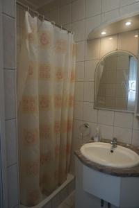 łazienka z umywalką i zasłoną prysznicową w obiekcie Hotel Ajka Üzletház Panzió Ajka w mieście Ajka +37 zdjęć