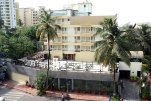 a building with palm trees in front of it at Hotel Metro Palace in Mumbai