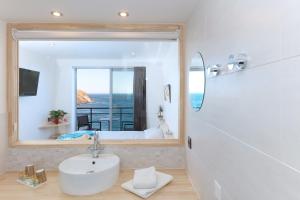 uma casa de banho com um lavatório e um espelho grande em Hotel La Vigie - Face à la mer em Cerbère