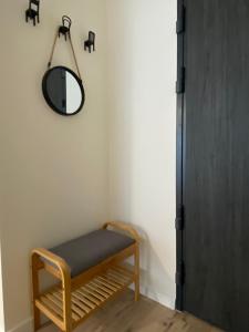 um quarto com um banco e um espelho na parede em Apartment Insat II em Szczecin