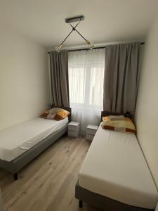 a bedroom with two beds and a window at Apartment Insat II in Szczecin