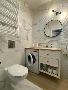 a bathroom with a toilet and a washing machine at Apartment Insat II in Szczecin