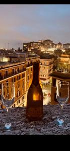 una bottiglia di vino seduta tra due bicchieri su un tavolo di A 2 Passi Dai Musei Luxury Guest House a Roma