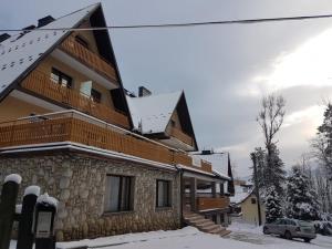 a house with snow on the roof of it at Willa Halusia in Zakopane