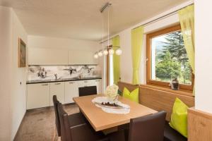a kitchen with a dining room table and a window at Alpin Sport in Ortisei