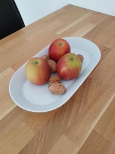 a plate with three apples and nuts on a table at Apartment B311 mit Pool in Lahnstein