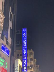 a blue sign in front of a building at Golden Star Hotel in Dubai