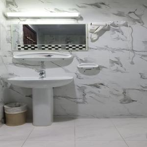 a white bathroom with a sink and a mirror at Golden Star Hotel in Dubai