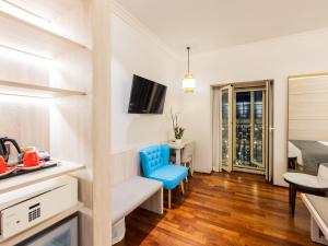 ein Wohnzimmer mit einem blauen Stuhl und eine Küche in der Unterkunft Preciados in Madrid